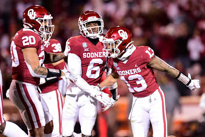 Tre Norwood (13) celebrates an interception with Robert Barnes (20) and Tre Brown (6).